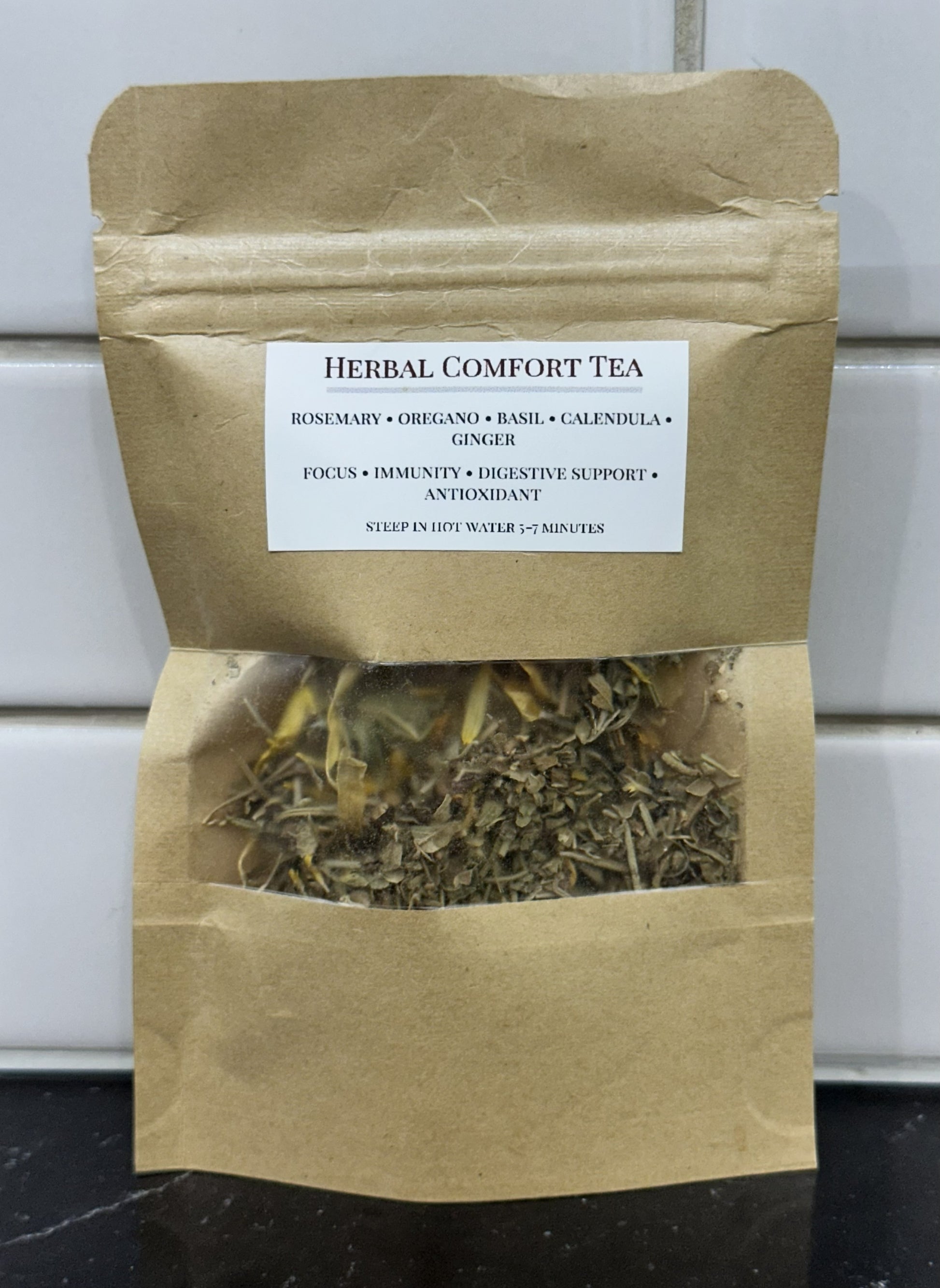 Herbal Comfort Tea kraft paper bag with window showing dried herb blend